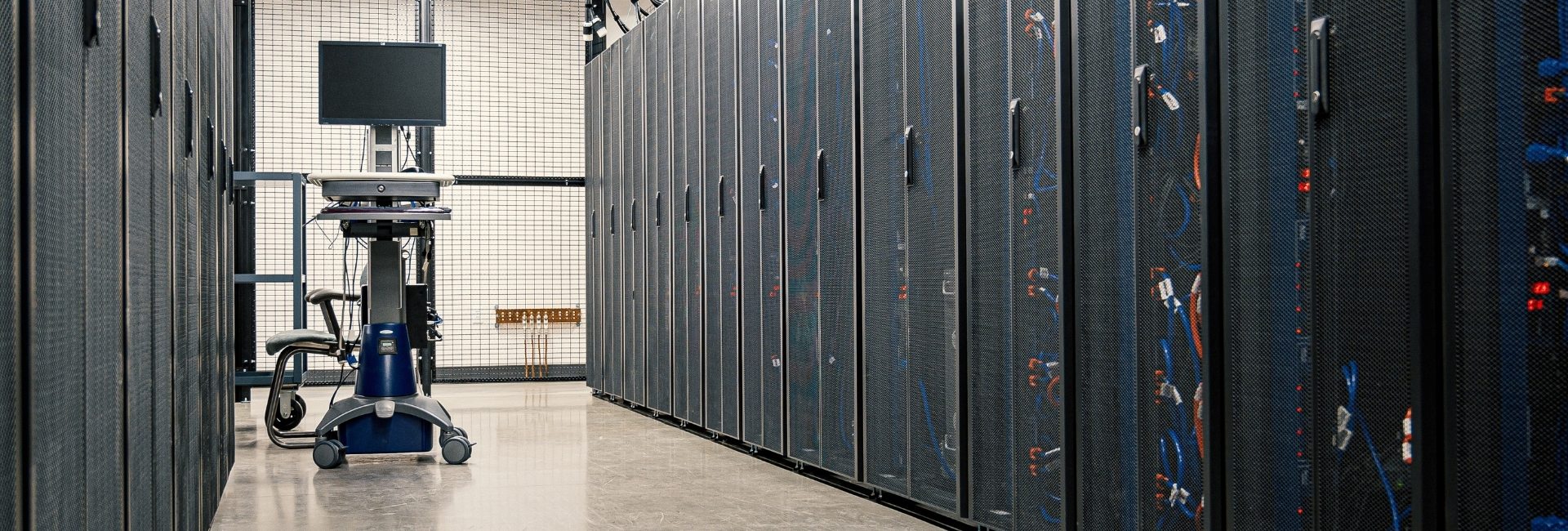 Interior view of a modern data center with active server racks and running equipment.